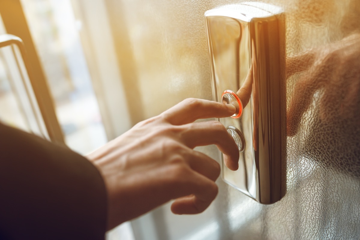 finger presses the elevator button