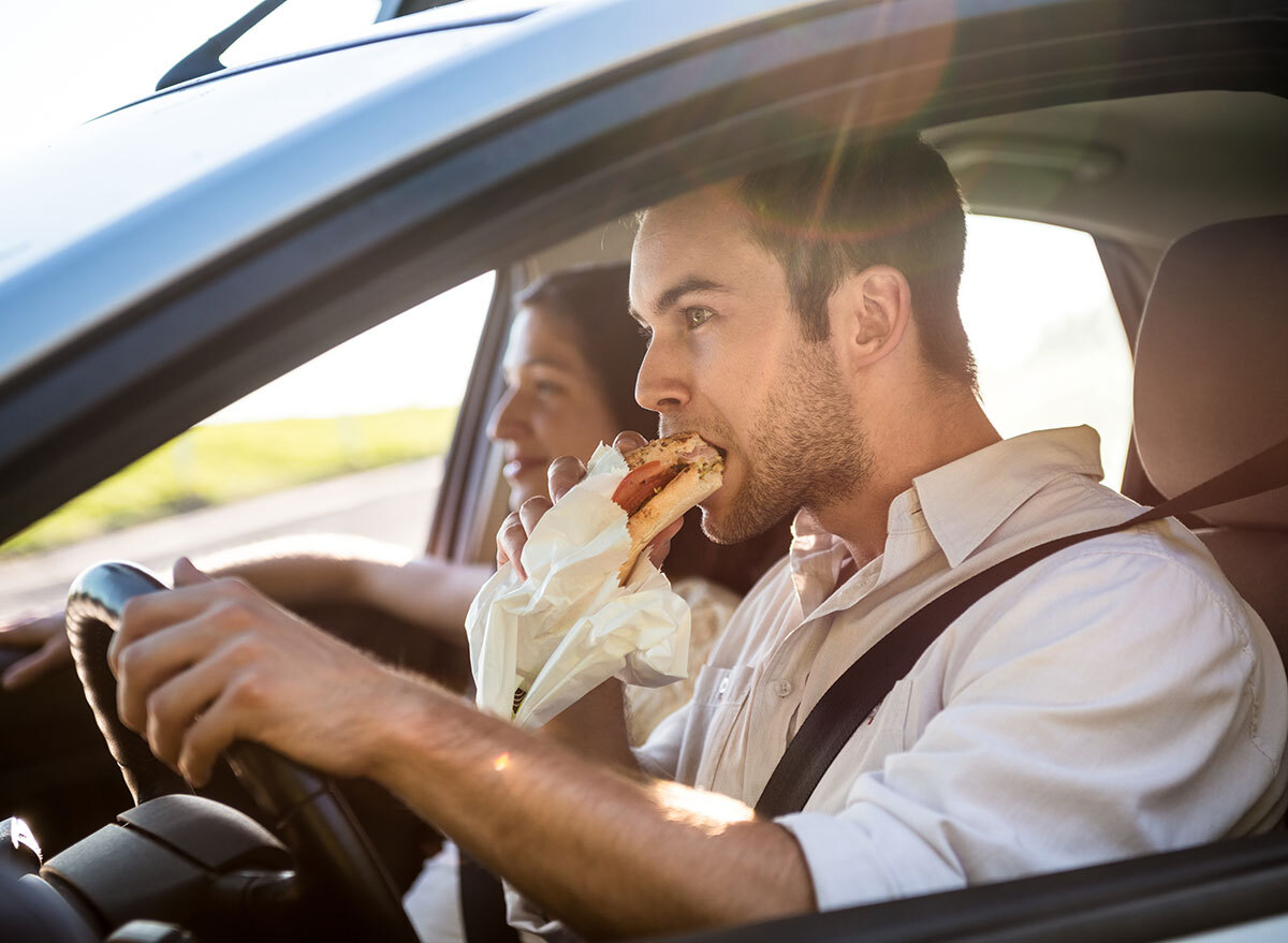 man eating in car