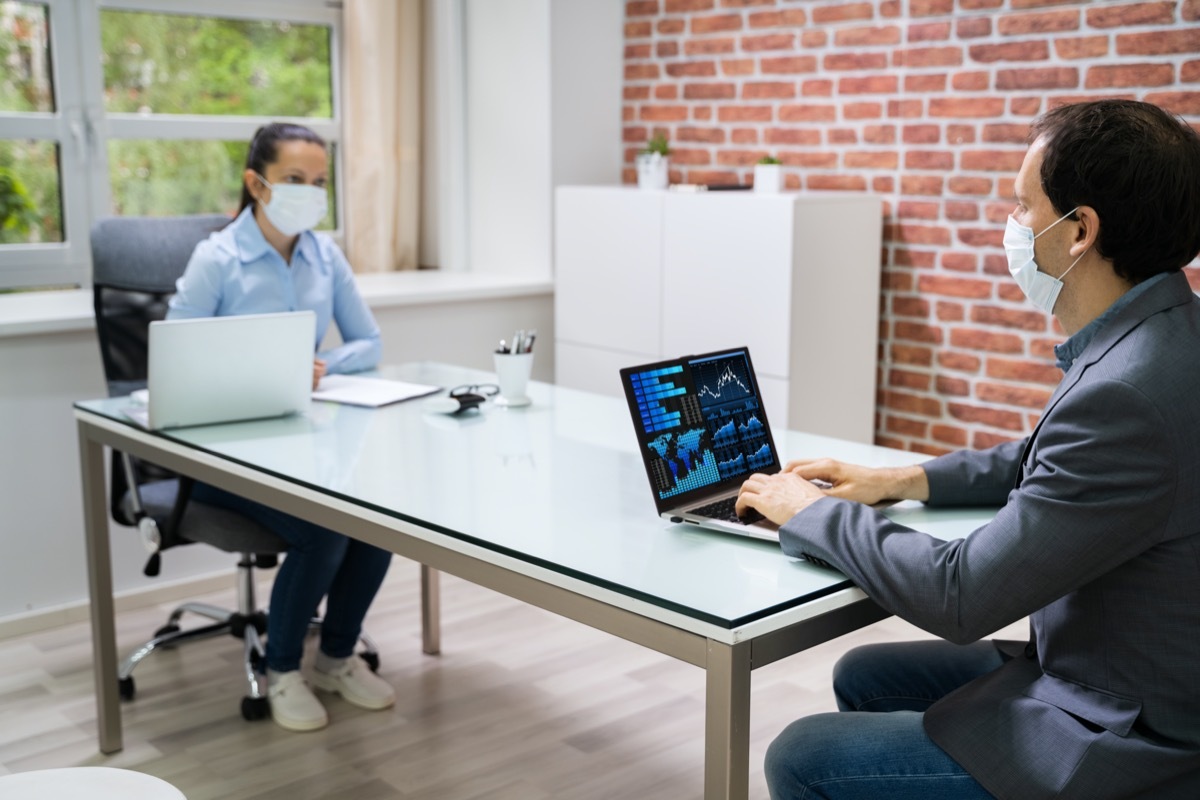 Computer Analyst Working On Laptop Wearing Face Mask