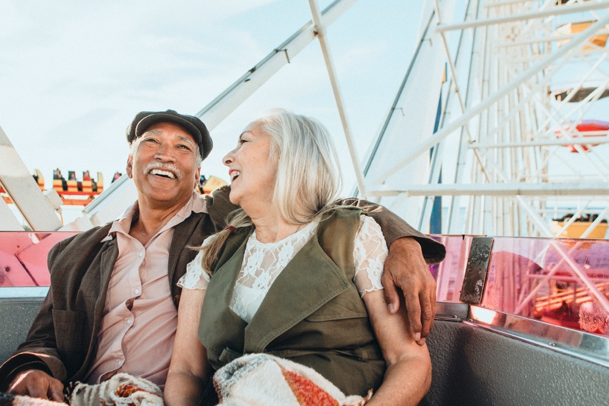 Cheerful senior couple enjoying a Ferris wheel by the Santa Monica pier