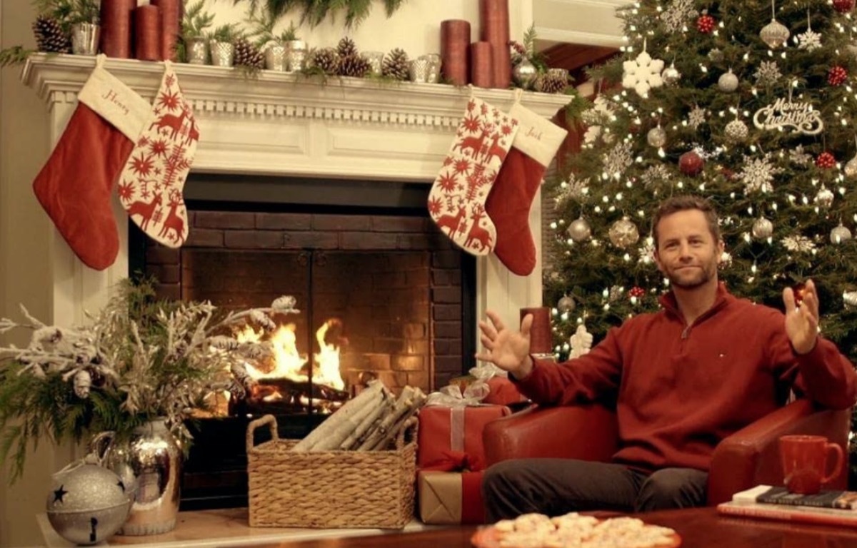 kirk cameron in front of fireplace in christmas clothing in saving christmas