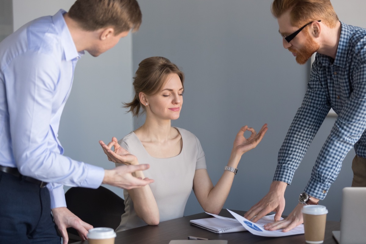 Woman Meditating to Block Out Two Men