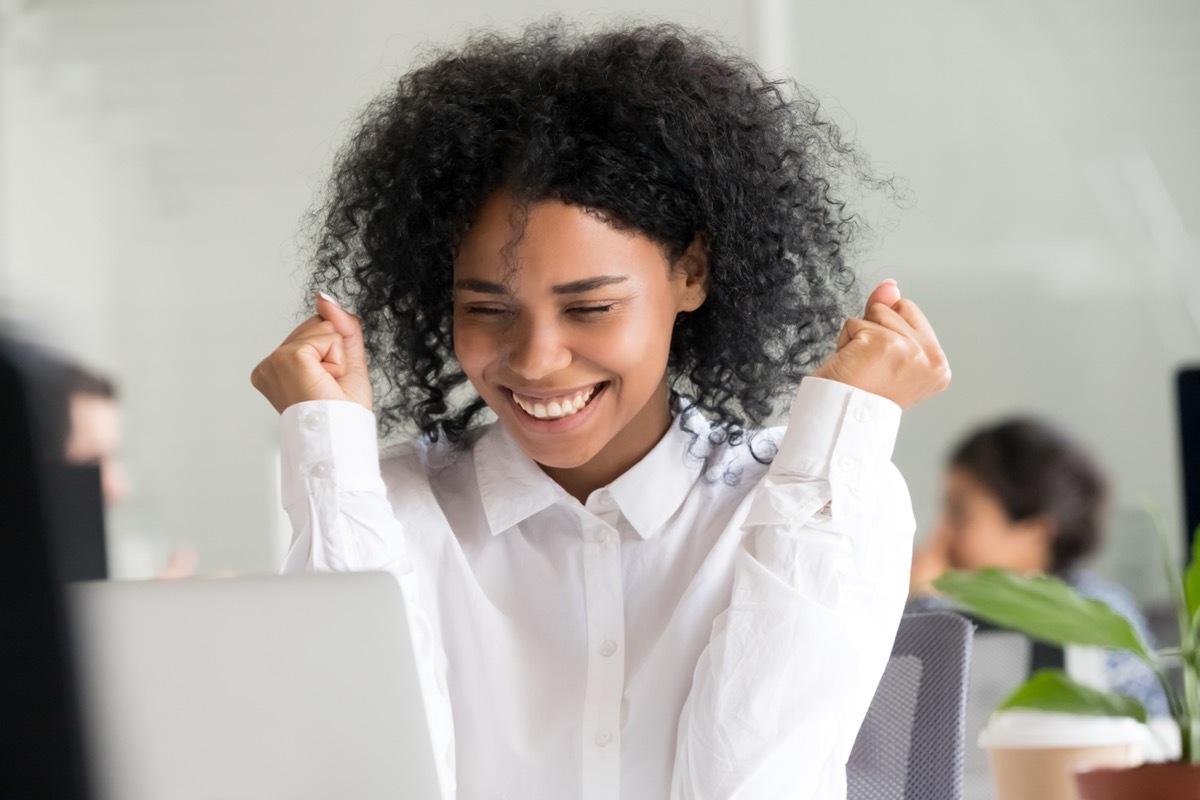 Woman looking at computer and celebrating