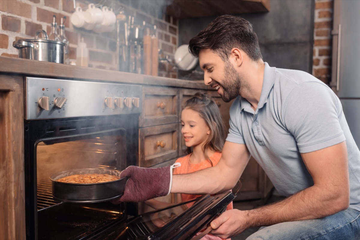 30 something white man and daughter opening steam oven