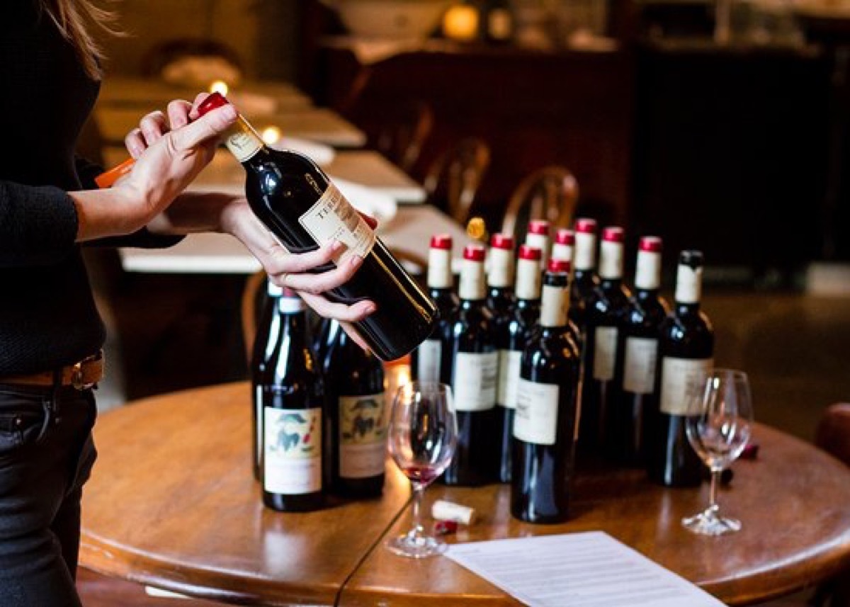 woman offering bottle of wine