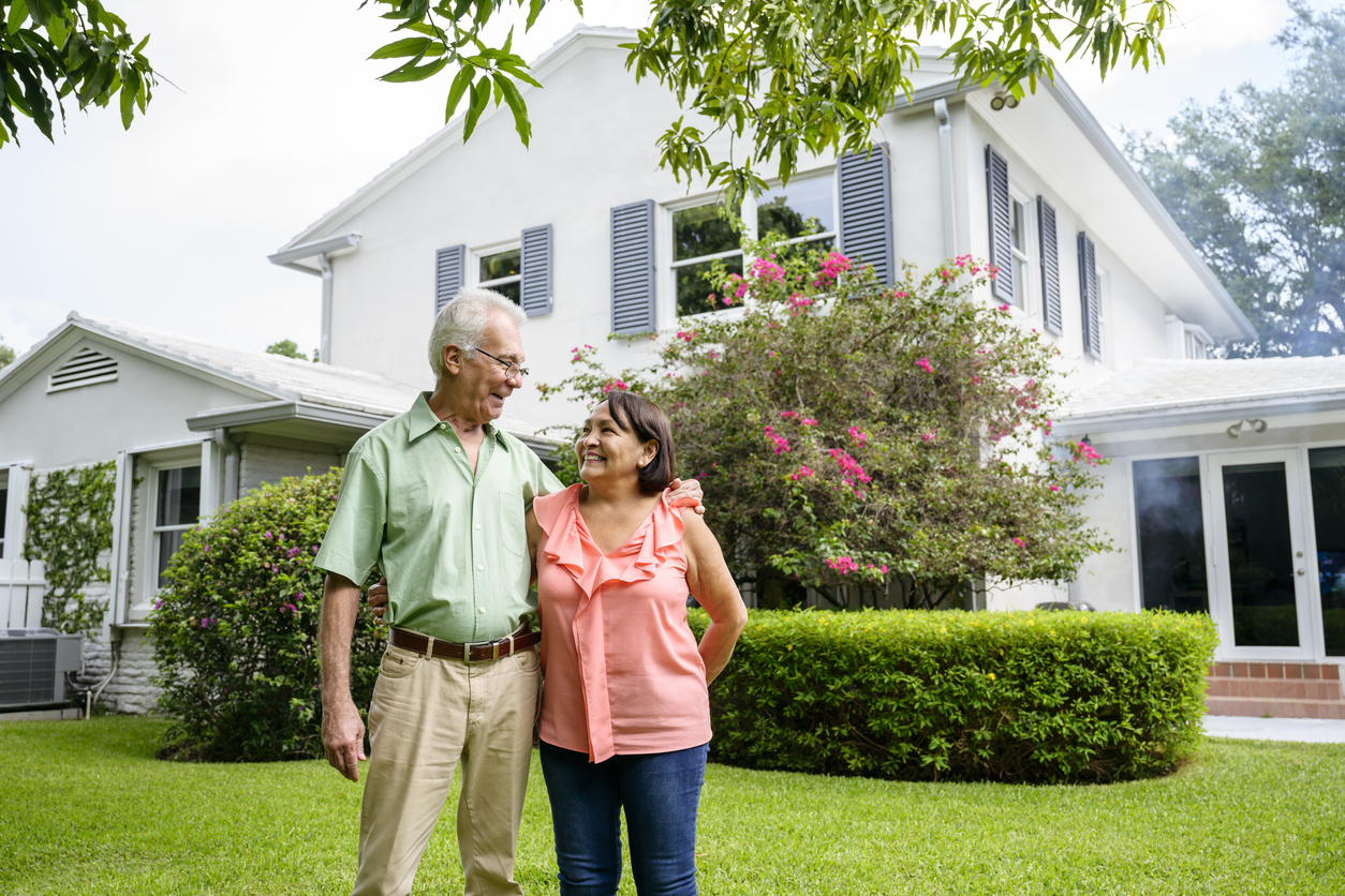 A senior couple hugging each other in their back yard