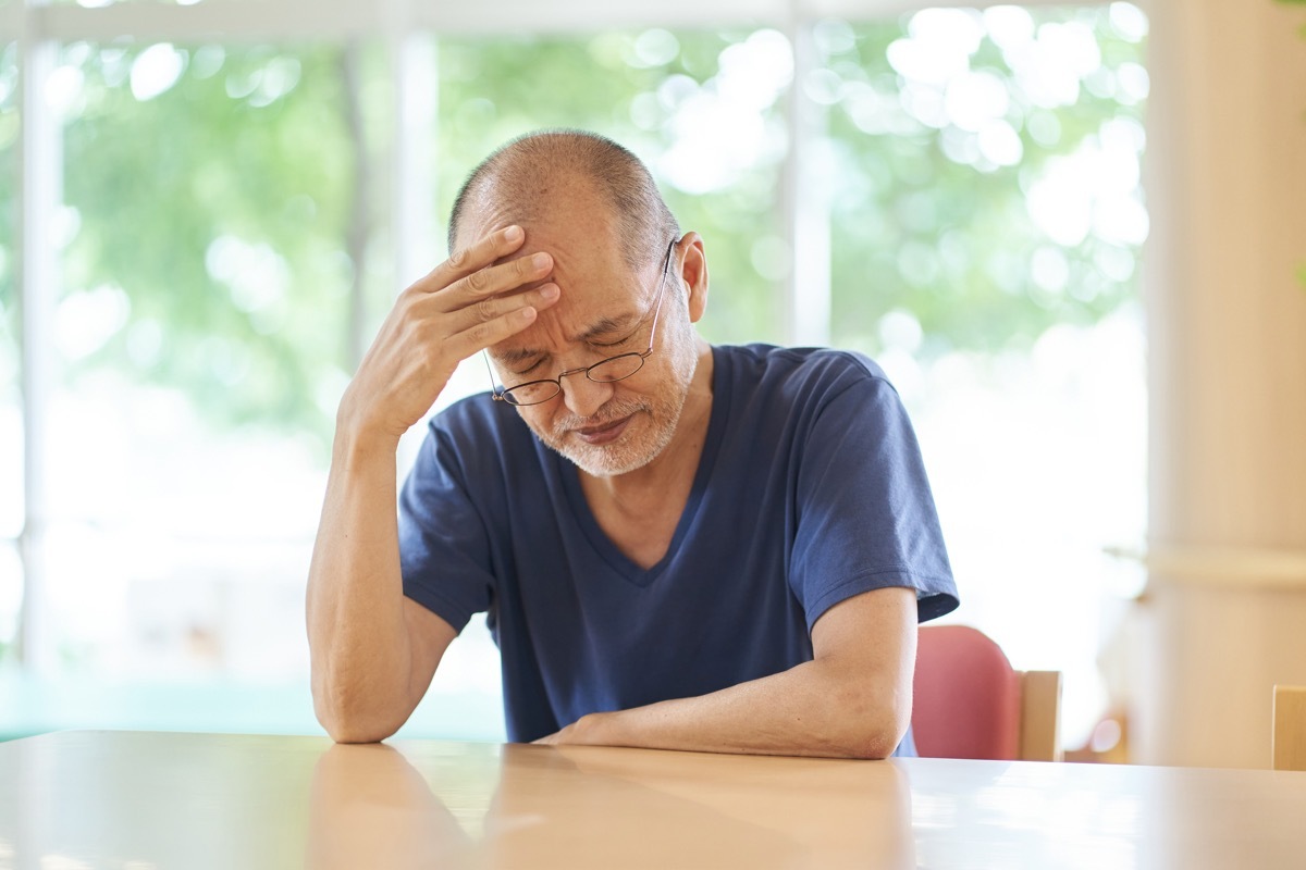 man with dementia holding head