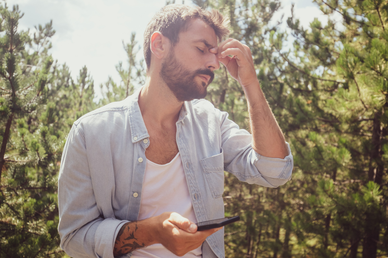 young man annoyed at his phone outside