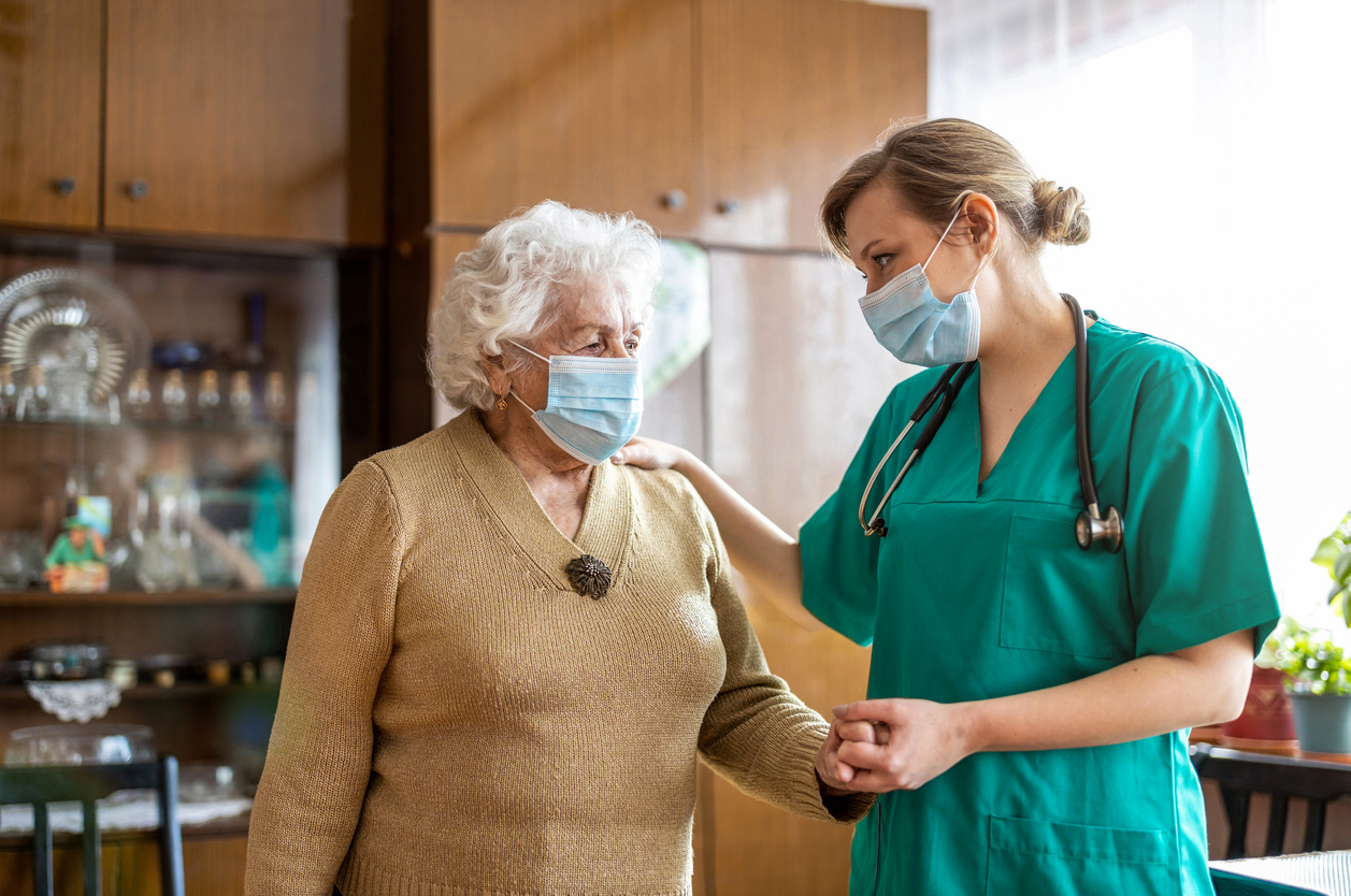 A nurse helps a senior woman around her home