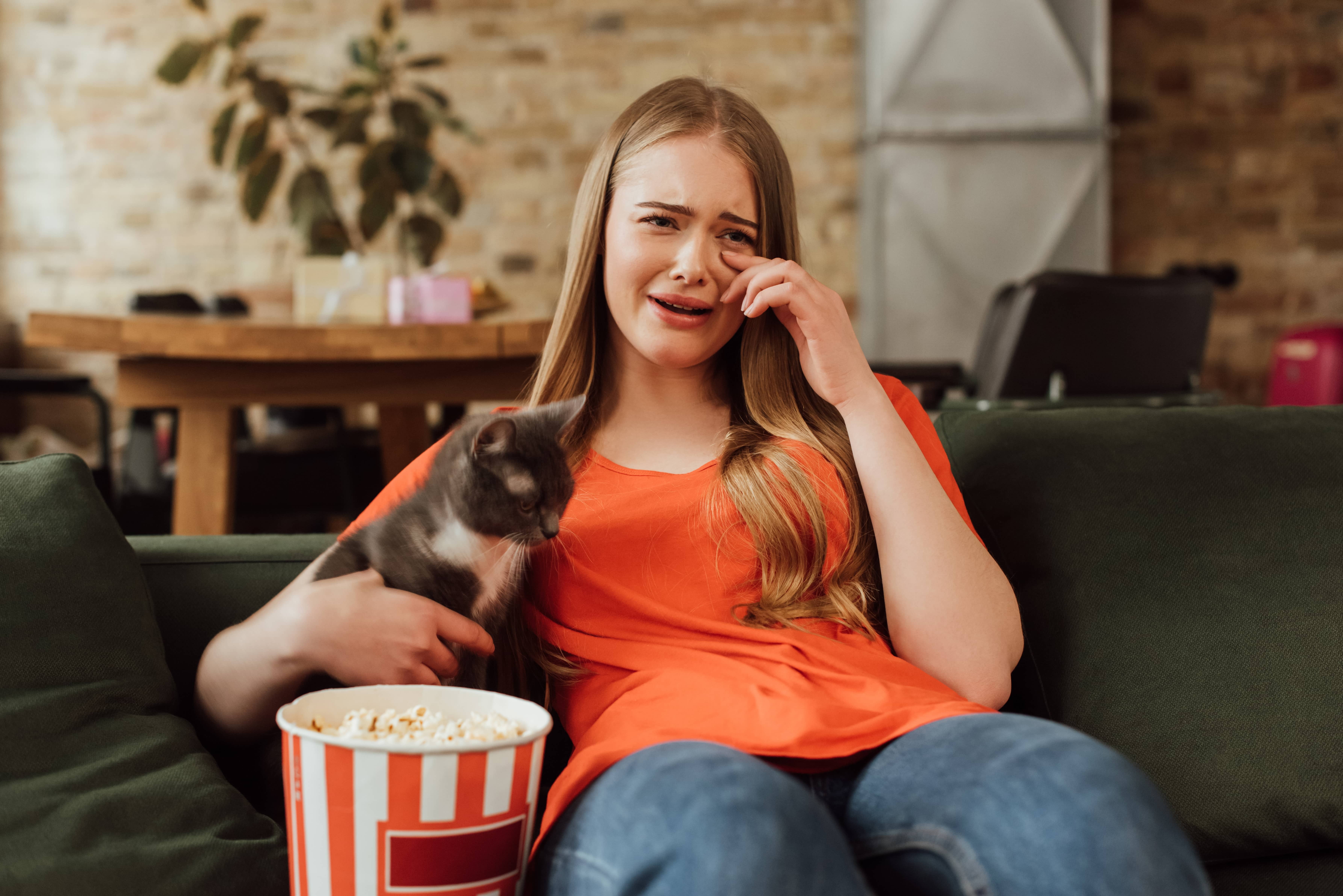 girl watching a movie with her cat and crying