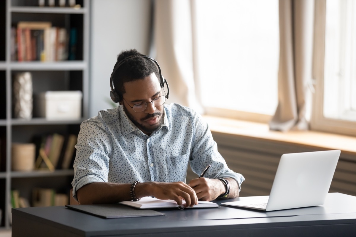 30-something black man working from home office wearing headphones