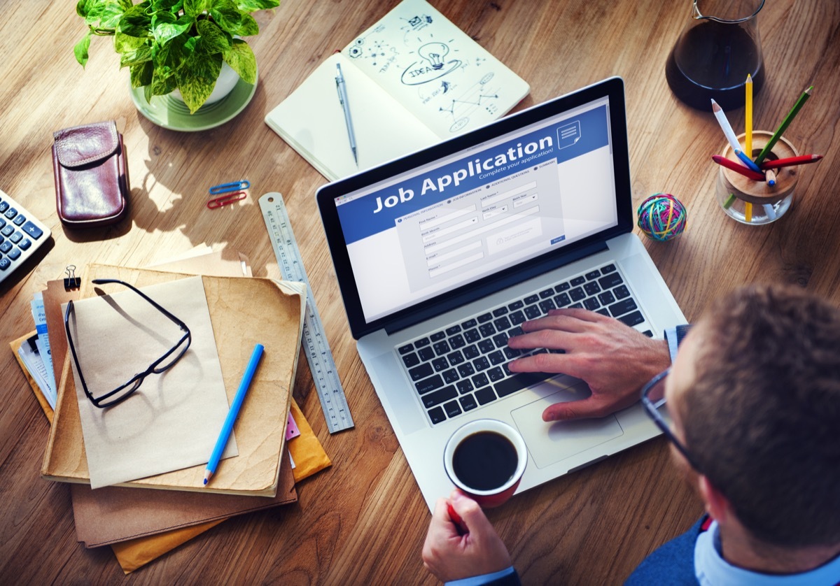 man filling out job application on laptop