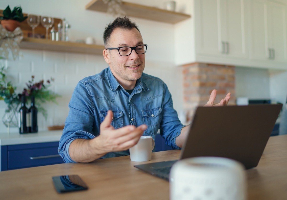 middle aged white man having a video chat conversation on his laptop