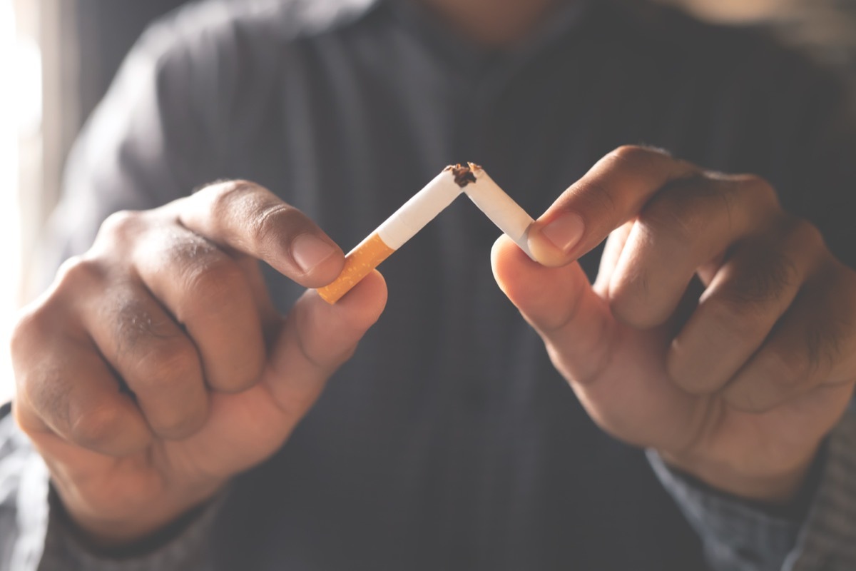 Person Breaking a Cigarette in Half