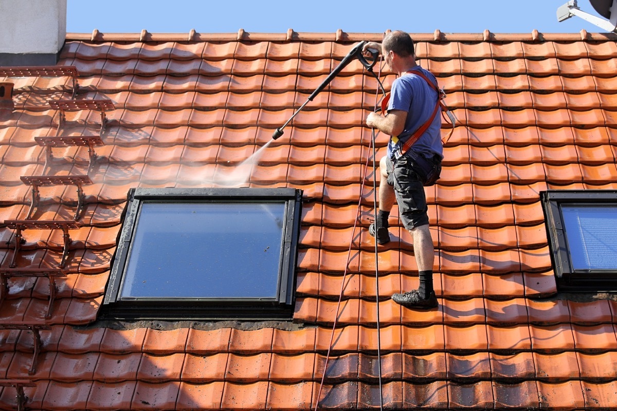 man power washing roof