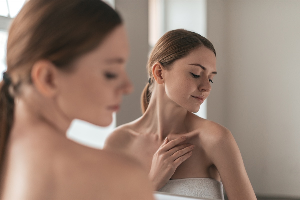 Woman looking at the skin on her shoulder