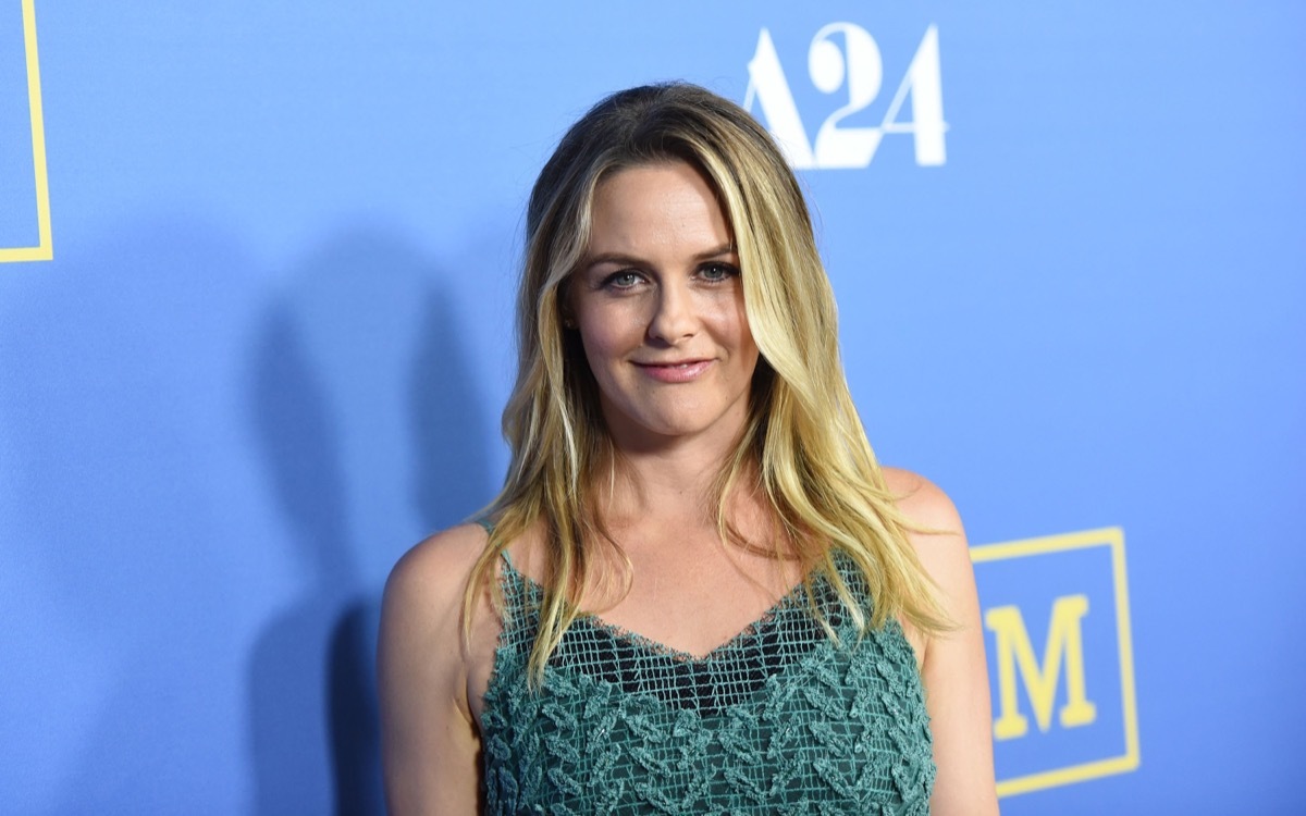 alicia silverstone smiling in green dress on red carpet