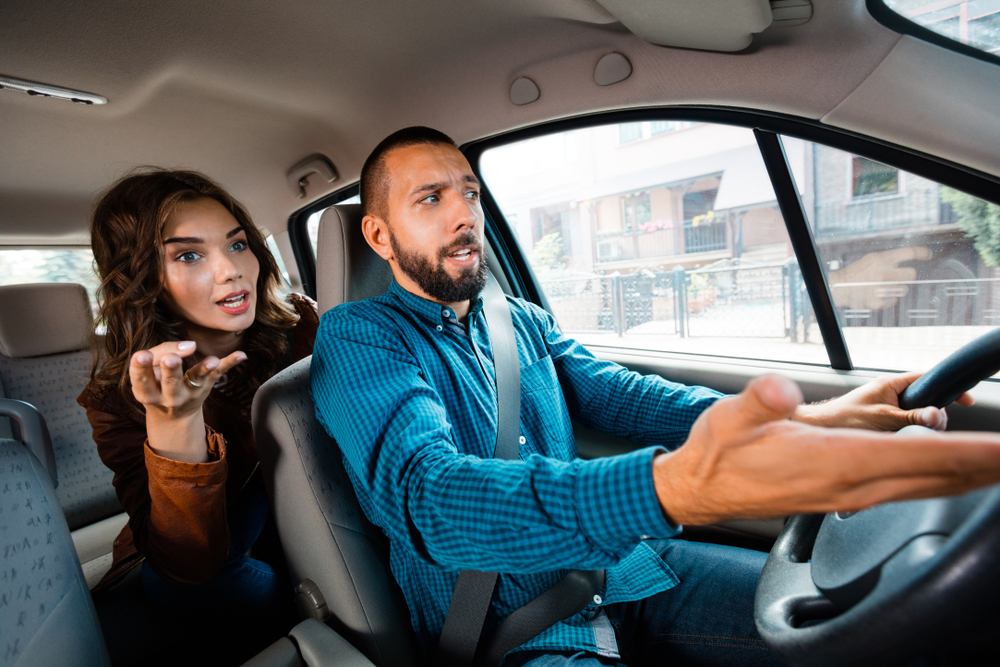 An Uber driver arguing with an angry passenger in the back seat