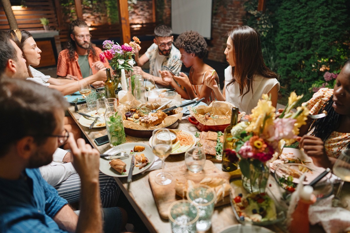 Friends and family having lovely garden dinner party in the summer, autumn