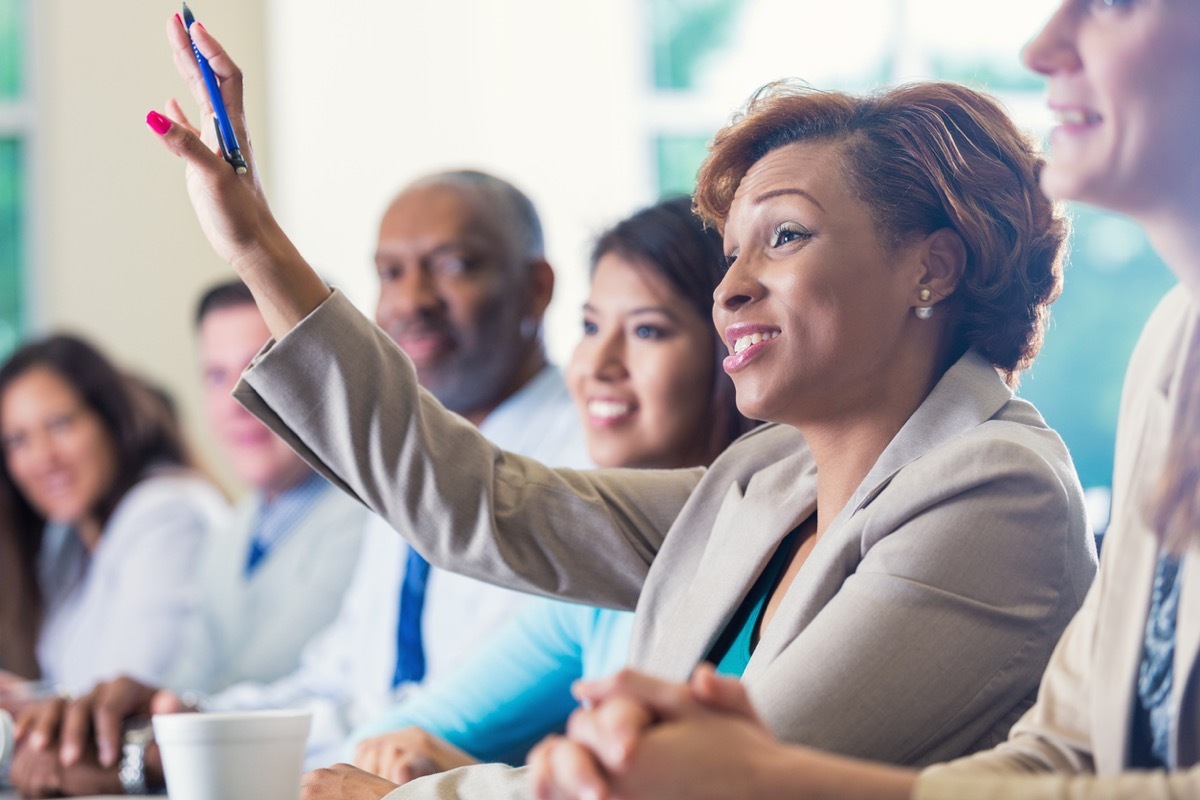 black businesswoman raising her hand in meeting at the office