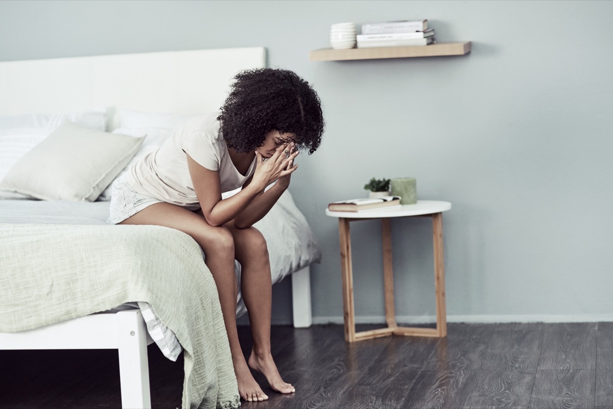 Shot of a young woman suffering from depression in her bedroom