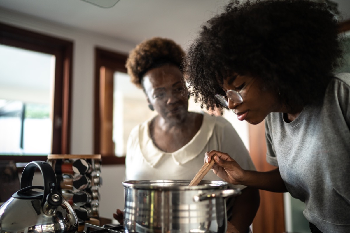 Daughter and mother cooking together at home