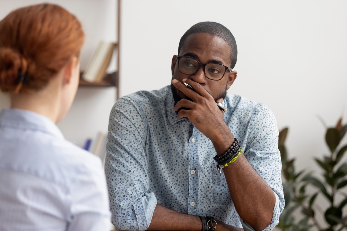 black man meeting with white redhead woman in an office