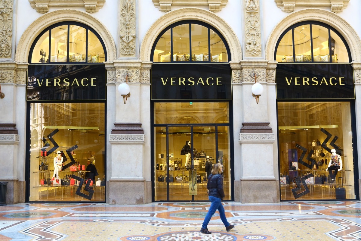 Milan, Italy - arch 23, 2015: a boutique of stylist Versace in Galleria Vittorio Emanuele II. A woman is walking in front of the store.