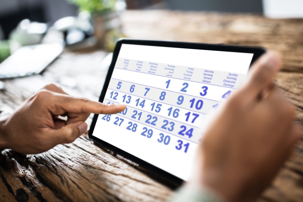 man using digital calendar on iPad.