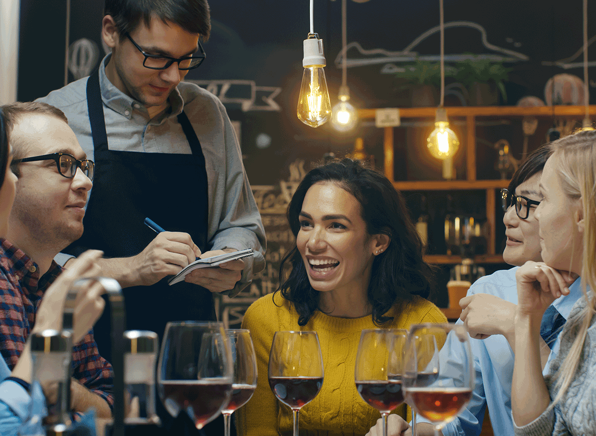 server taking notes for group of friends with drinks