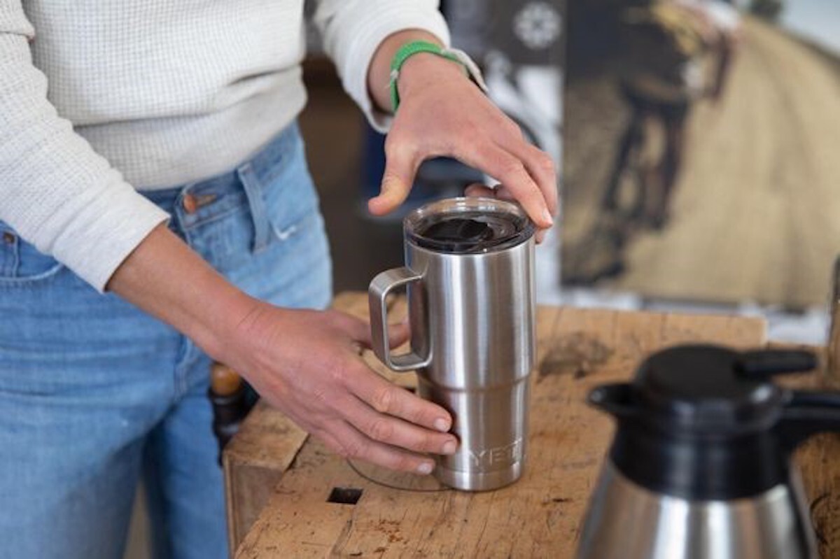 closeup of woman's hand securing lid on yeti travel mug