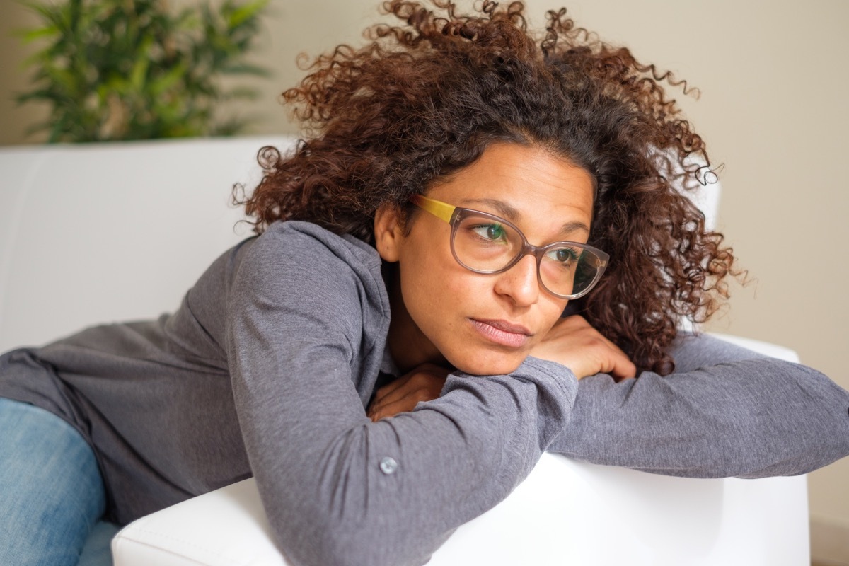 Woman feeling negative emotions lying on the sofa