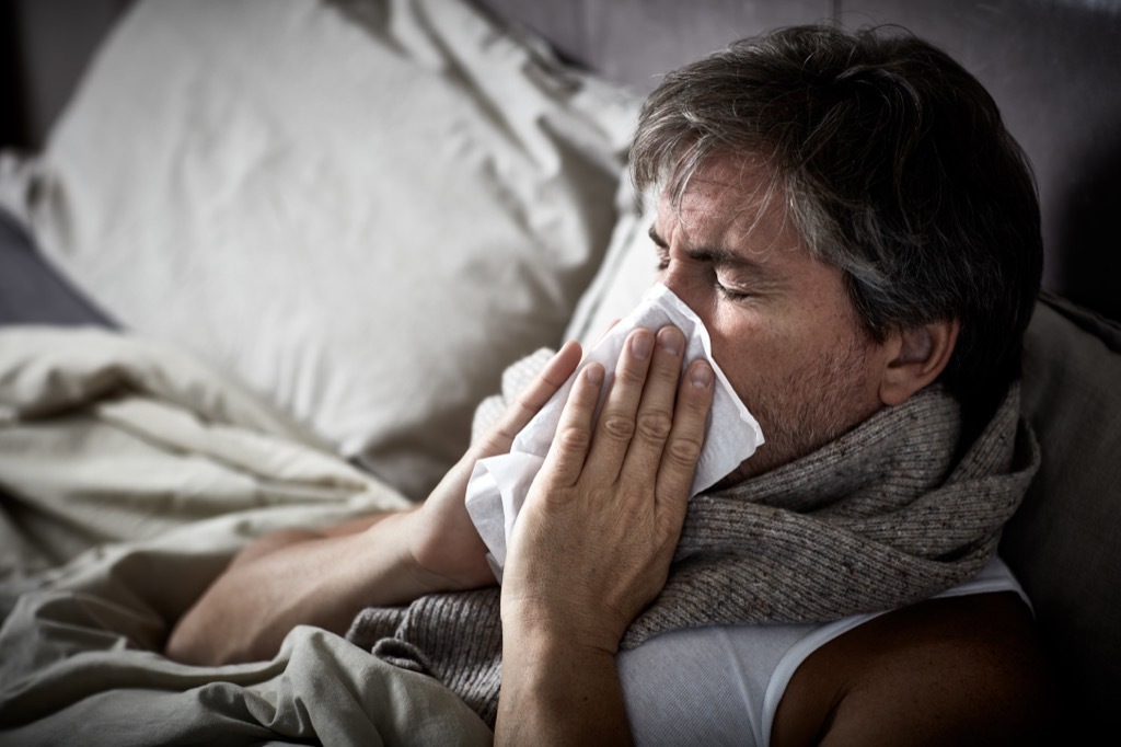 man sneezing in bed, ways your body changes after 40