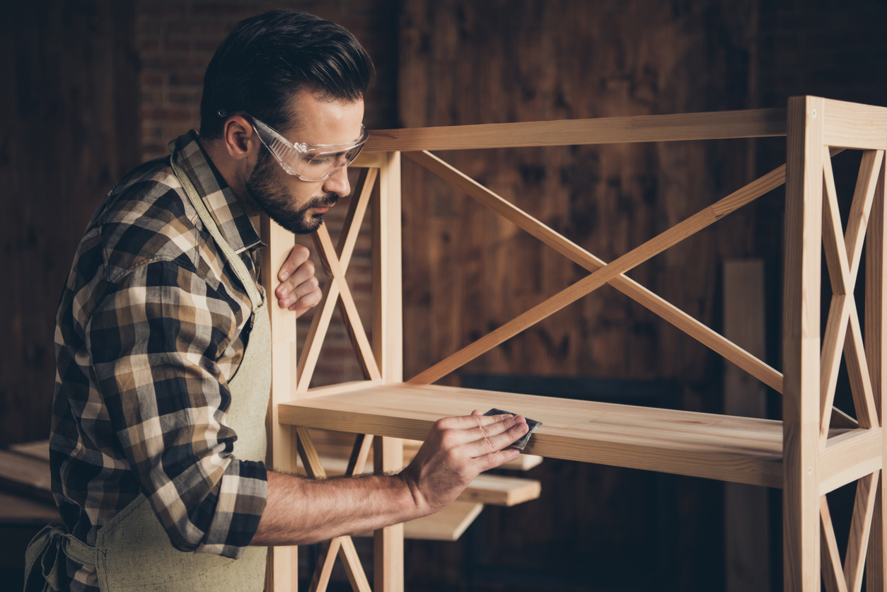 young man building bookshelf at home