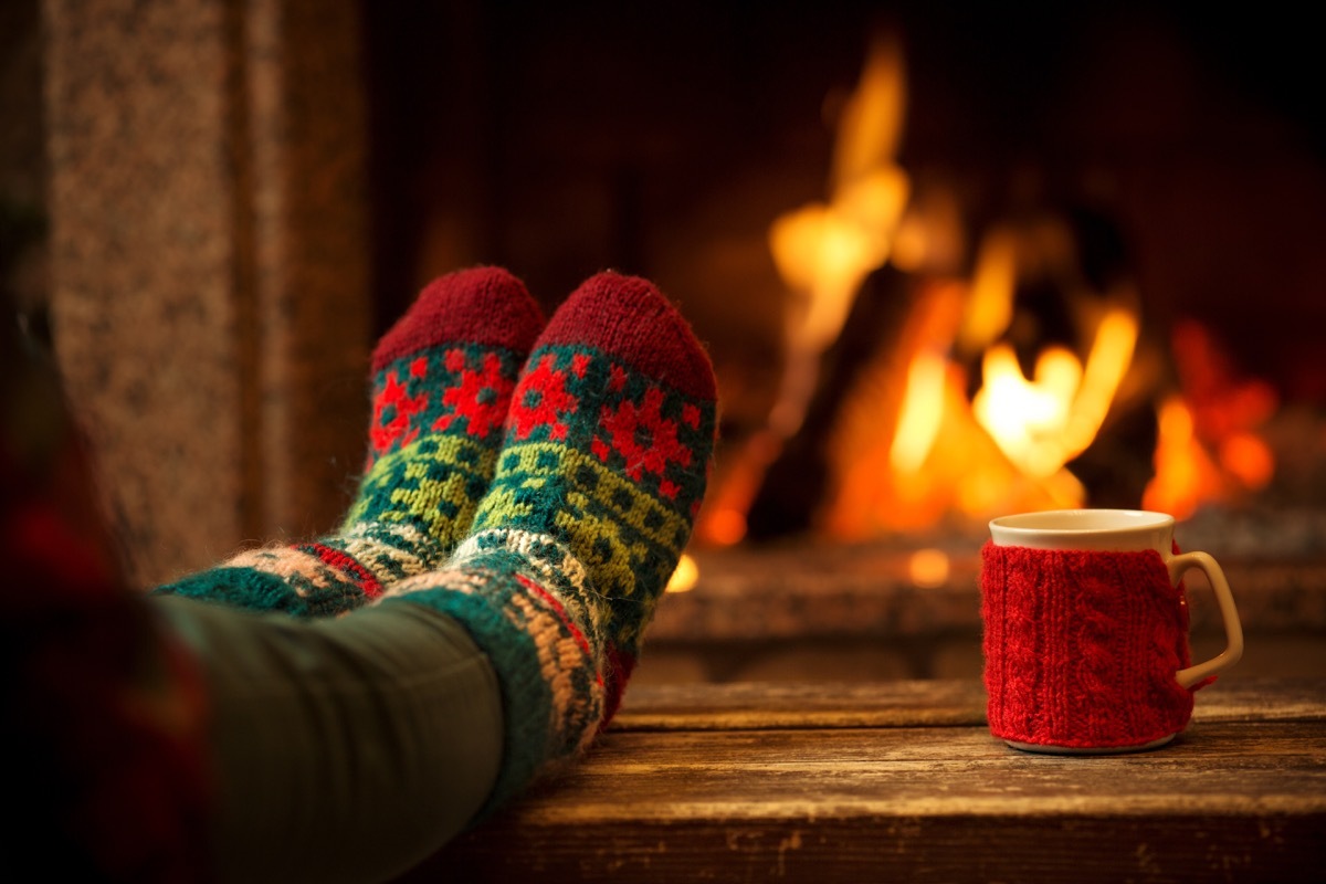 feet in woollen socks by the christmas fireplace