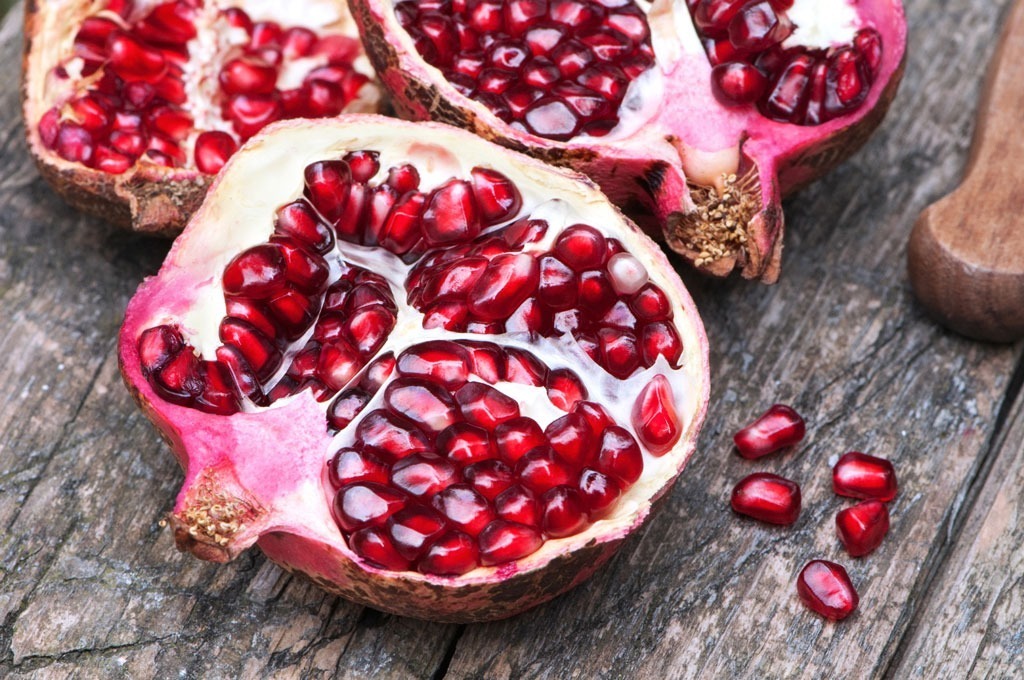 Cut pomegranates on wooden table