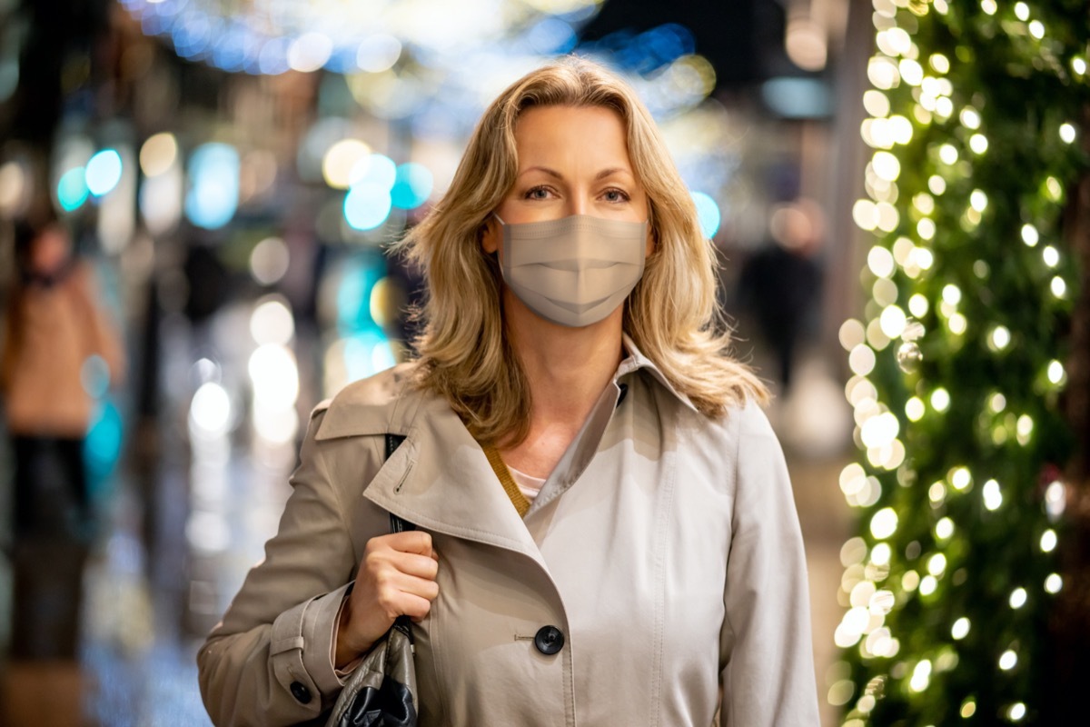 Woman wearing a facemask while shopping for Christmas in London