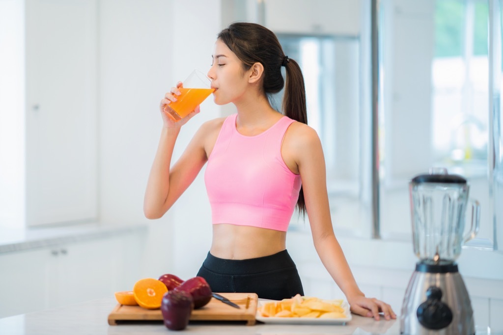 woman drinking orange juice, stomach symptoms