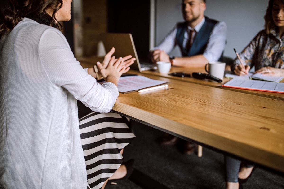 Man accompanied with two women sitting in board room and having business interview