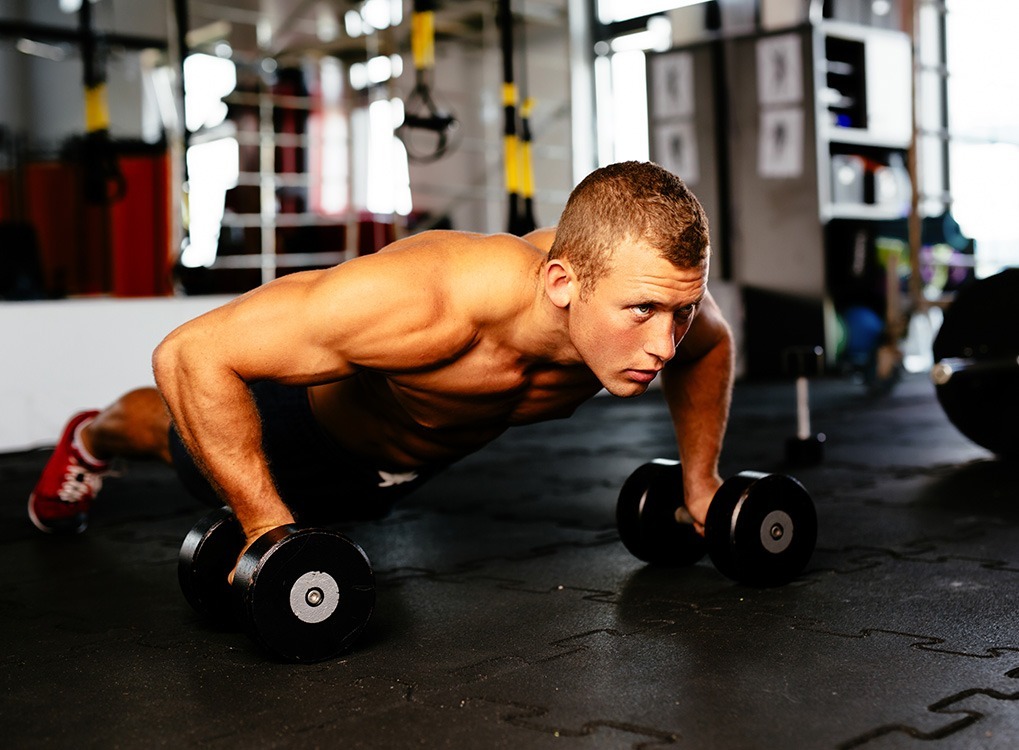 man and woman exercising cardio workouts for men over 40 man with weights at the gym 