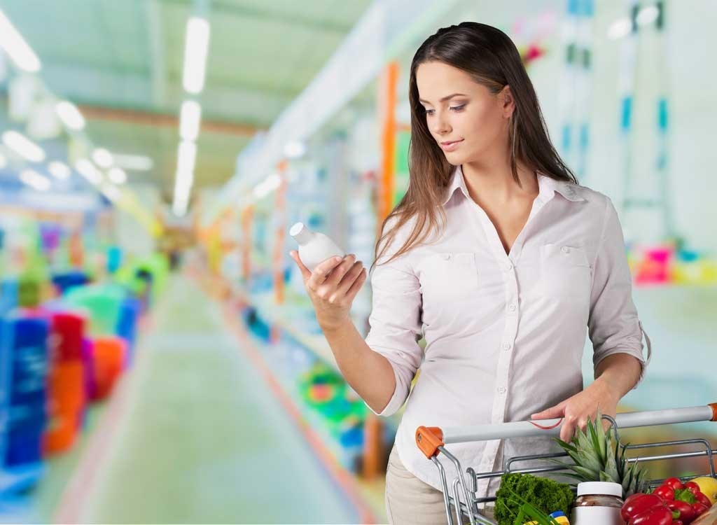 Woman looking at bottle in grocery store