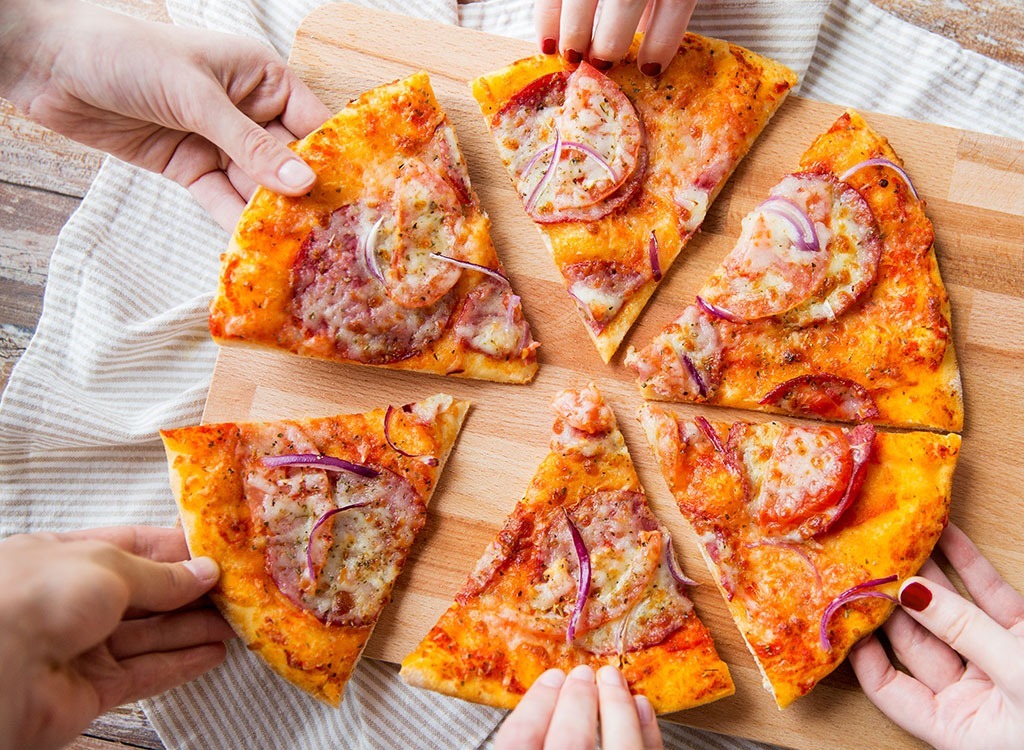 hands grabbing pizza