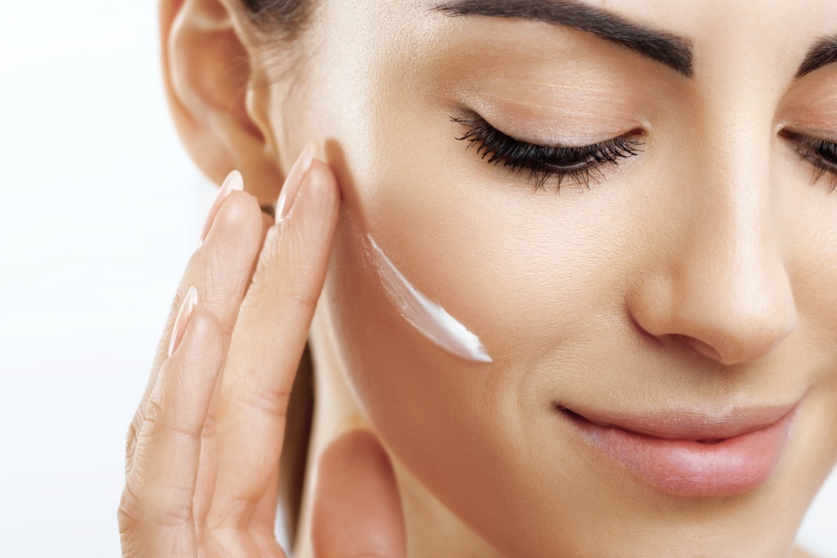 woman applying cream to her face