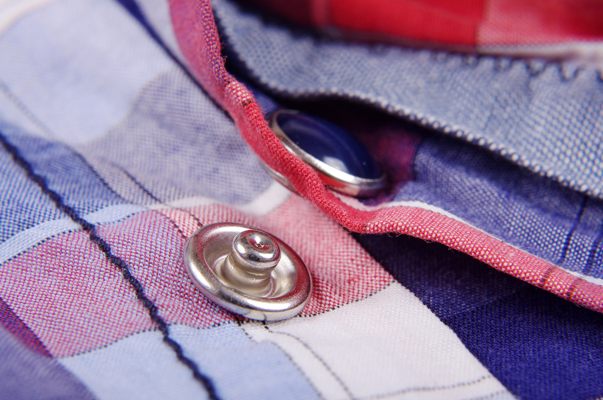 Close up of a red, white, and blue flannel shirt with metal snaps