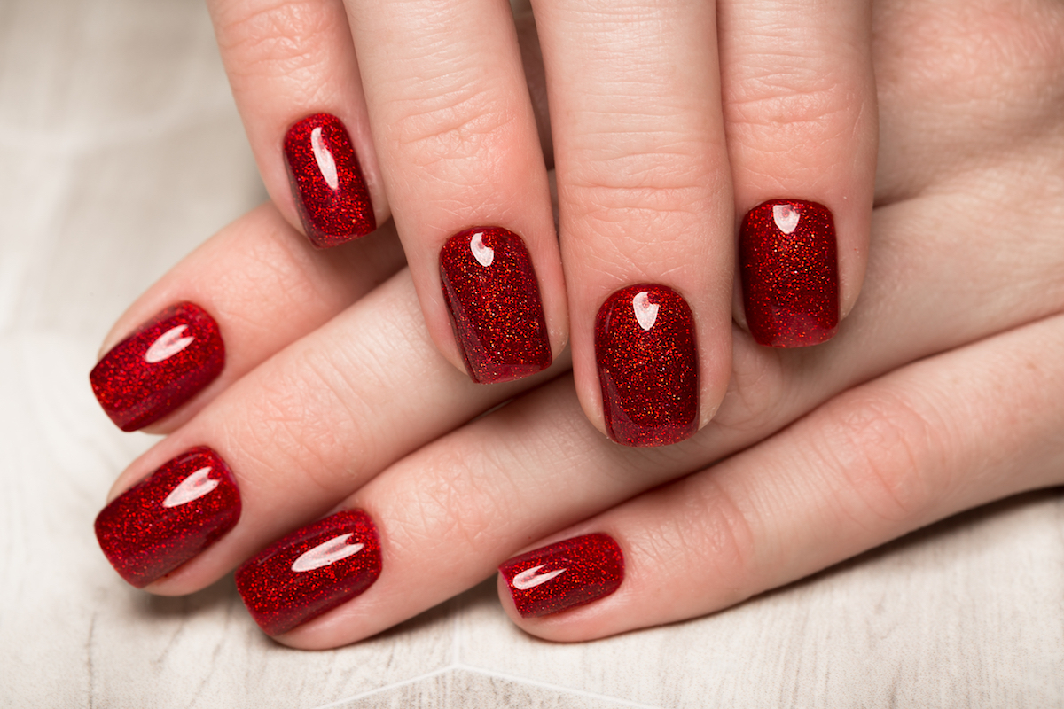 Bright festive red manicure on female hands. Nails design.