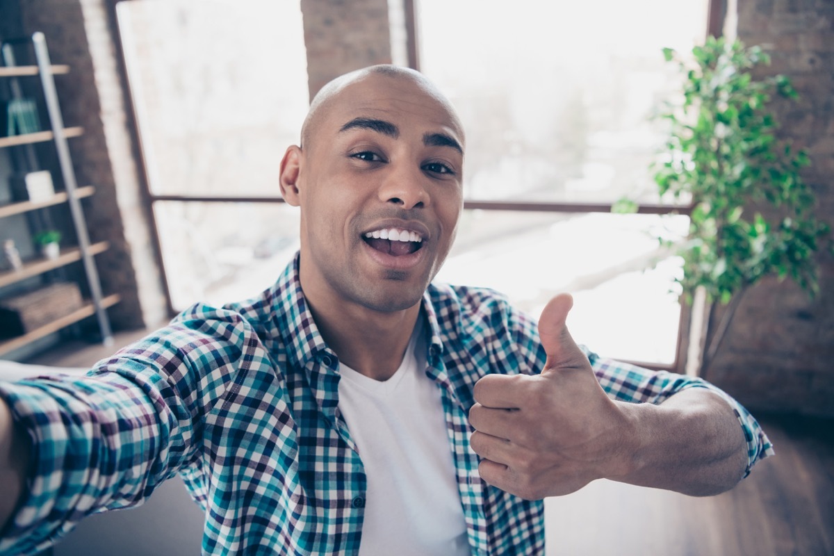 young black man taking a selfie and giving a thumbs up