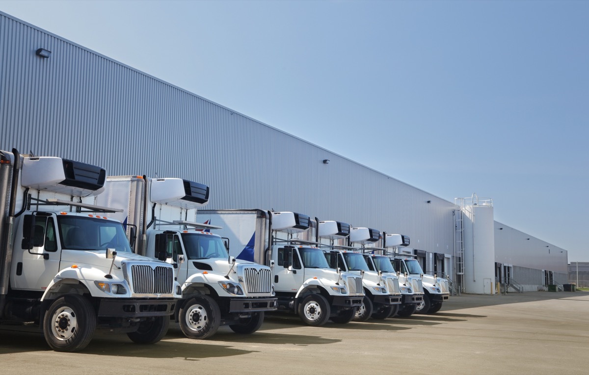 trucking company with trucks parked outside of warehouse