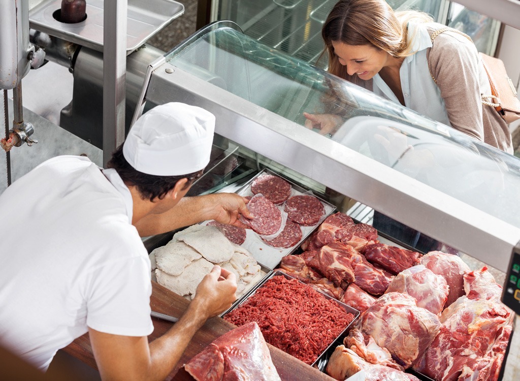 Woman shopping for meat at butcher counter