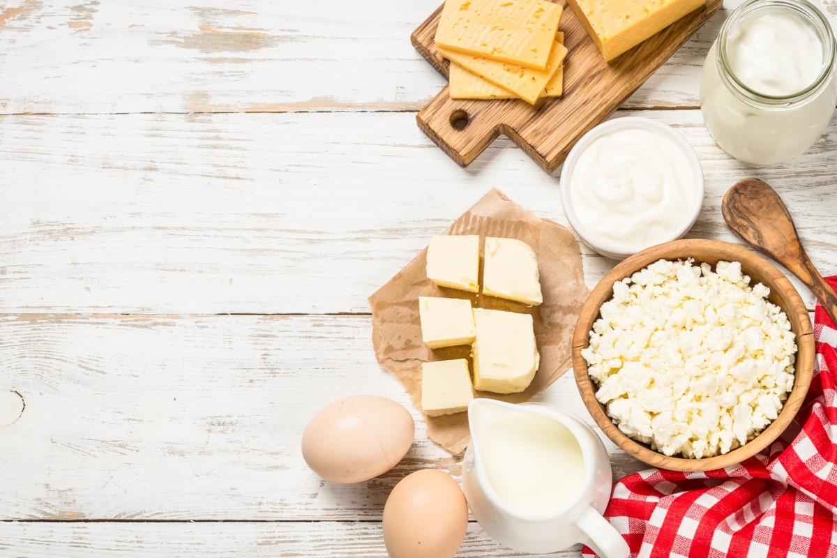 Dairy product at white wooden table. Curd, milk, yogurt, cheese and eggs. Organic farmer food. Top view with copy space.