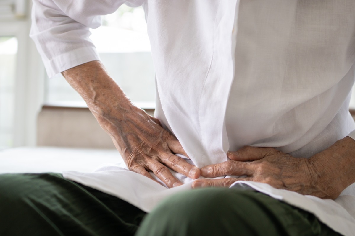 Sick senior patient having aching belly,hands hold stomach,stomachache,old people with symptoms gastrointestinal system disease,crampy abdominal pain hurt in stomach caused by indigestion or diarrhoea